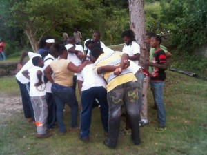 Members of the Snell Hall Sports and Cultural Club huddle around to recommit to the cause of constructing a Resource Centre and Playing Field in their community